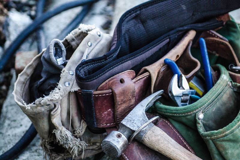 Ceinture à outils et matériel d'artisan posés sur un établi
