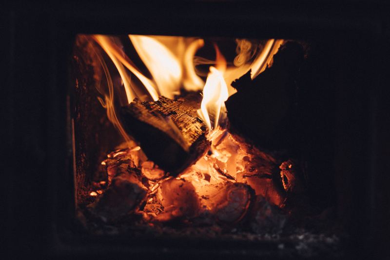 Poêle à bois en fonte avec flambée visible derrière la vitre